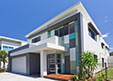 Contemporary white home with geometric design and lush lawn.