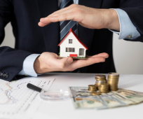 Business suit hands with model home and money, denoting home loan services