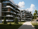 Modern apartment buildings with balconies surrounded by greenery.