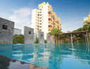 Resort-style swimming pool with apartment buildings in the background