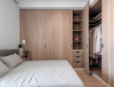 Minimalist bedroom with an open wardrobe and a bed with grey bedding